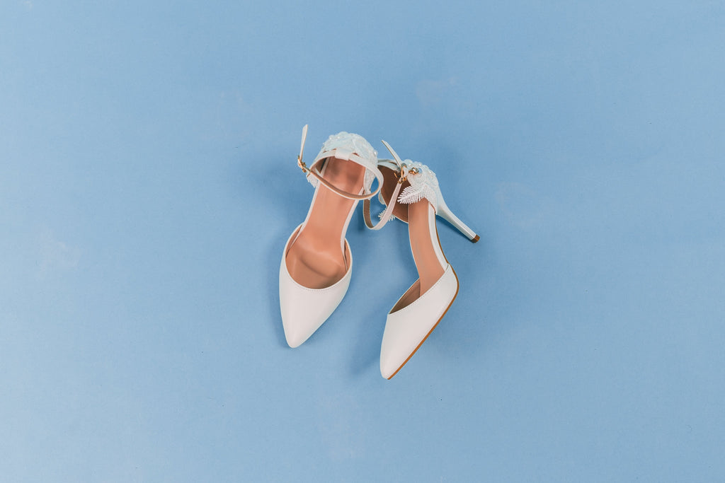 White high-heeled shoes on a light blue background
